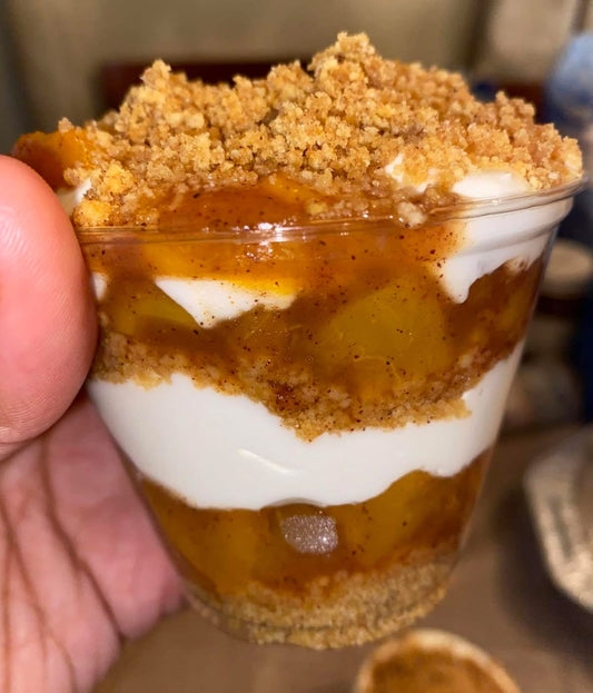 These Peach Cobbler Cheesecake Cups feature creamy cheesecake filling, buttery graham cracker crust, and sweet cinnamon peaches for the ultimate summer dessert.